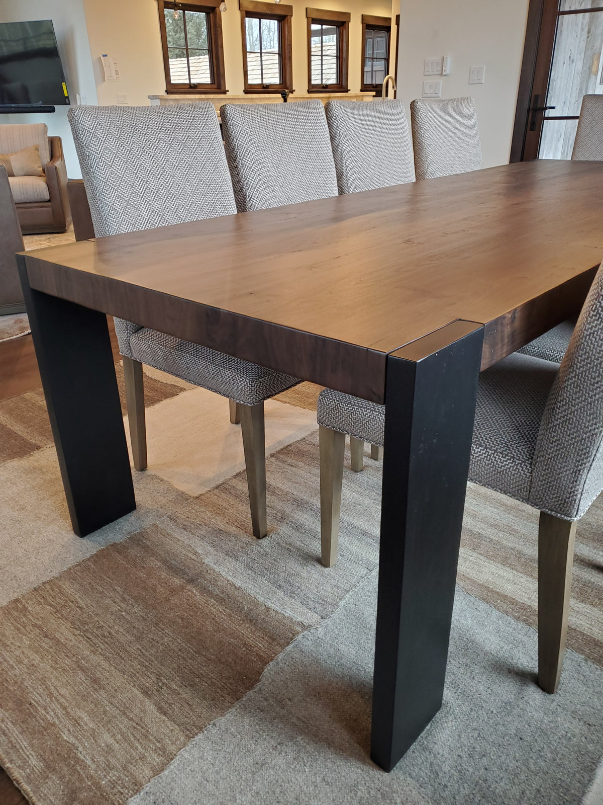 A custom Parson dining table by JC Barger with upholstered dining chairs